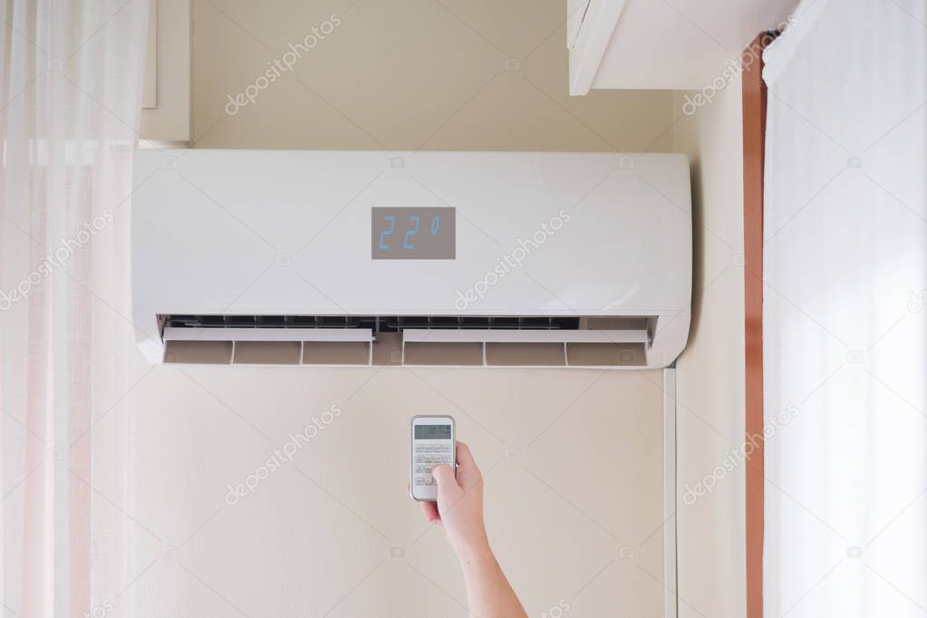 Air conditioner mounted on the room wall and temperature remote control