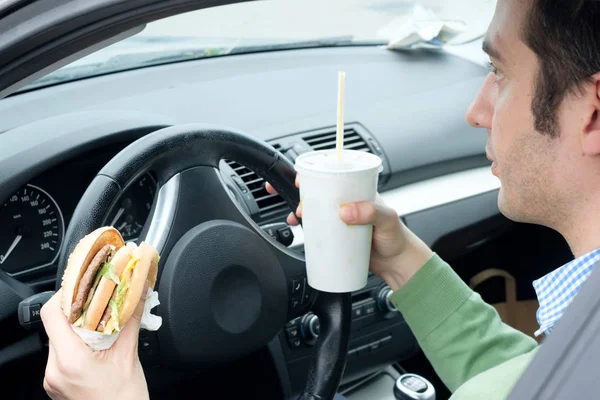 彼の車を運転して交通の食品を食べながら大人の男 — ストック写真