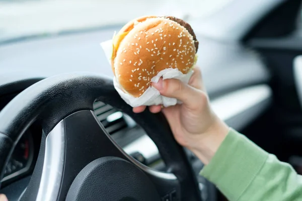 交通の食品を食べながらホイールでドライバーの手のクローズ アップ — ストック写真