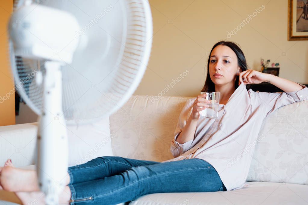 Young woman drinking water and relaxing in the summer heat