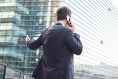 Arkadan görünüşü telefonda konuşurken sinirli modern yemlik