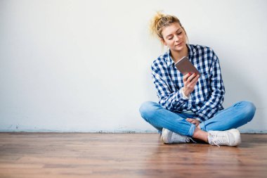 Katta oturan ve smartphone kullanarak kız