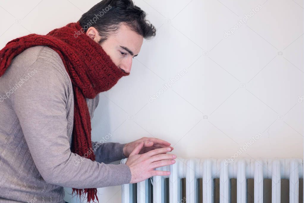 Man feeling very cold at home with warm clothes