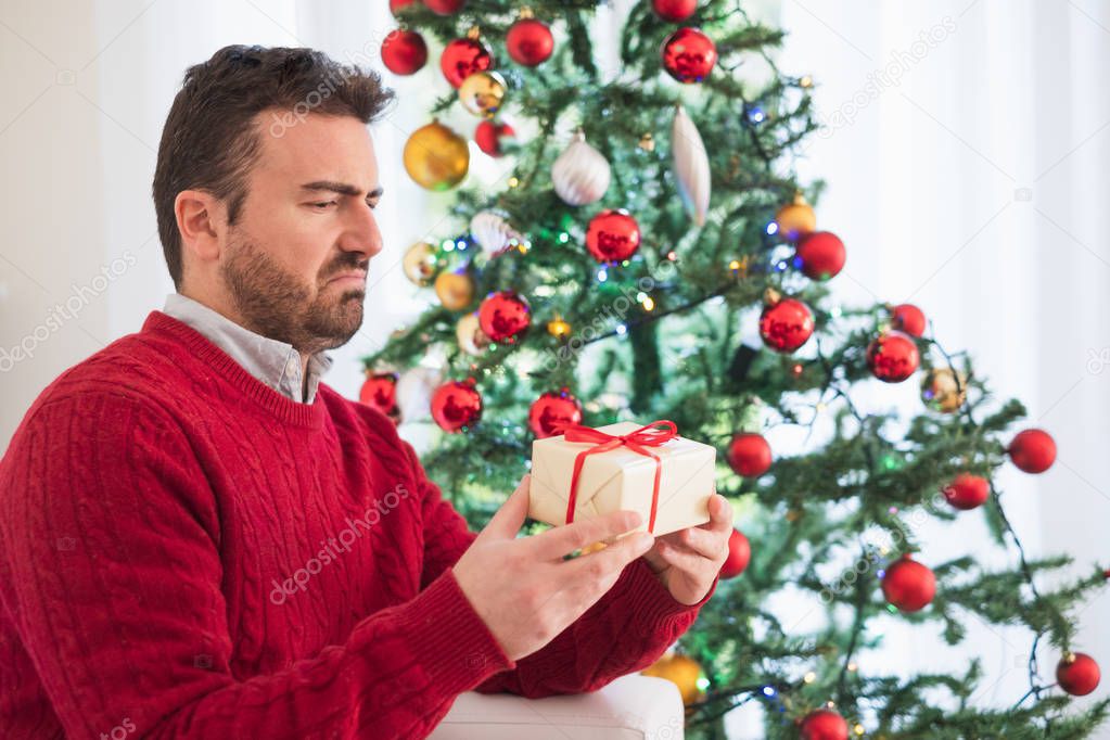Disappointed man receiving small present for christmas
