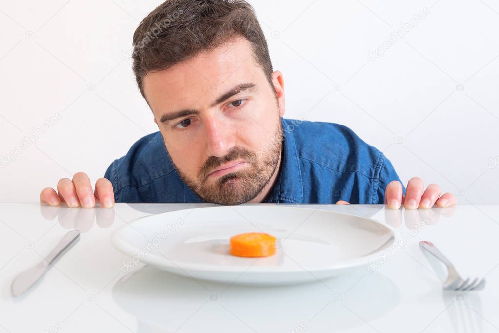 Sad and hungry man watching poor diet meal