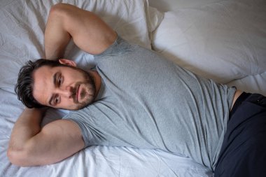 Dinlenmiş uygun adam rahat hissediyor yatakta yatan