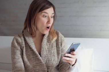 Cep telefonu tutan sürpriz kadın yüz ifadesi