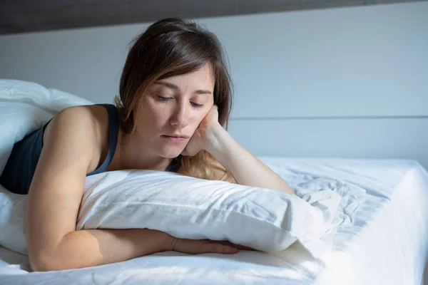 Sad woman can\'t sleep lying in her bed at home