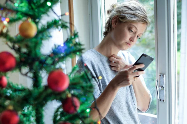 Vrouw Een Depressief Gevoel Tijdens Kerstdagen Kijken Naar Mobiel — Stockfoto