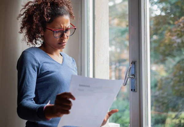 Portrait of worried black woman standing beside window