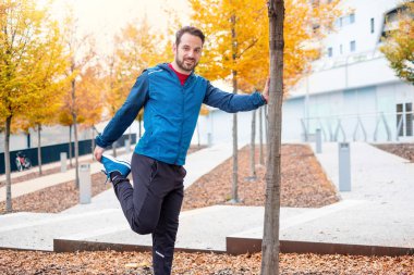 Sportif giysiler bacak yapıyor adamla egzersizleri uzanır