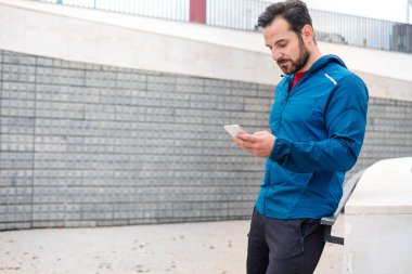 Atletik eğitim oturumu ile smartphone yapan adam