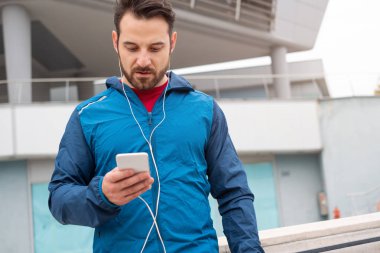 Atletik eğitim oturumu ile smartphone yapan adam