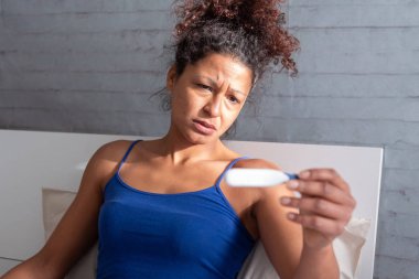 Hamilelik testi sonucu izlerken üzgün siyah kadın
