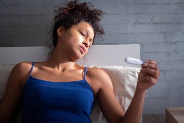Hamilelik testi sonucu izlerken üzgün siyah kadın