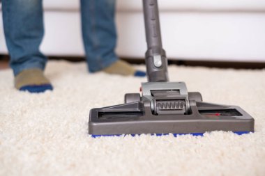 Beyaz halı elektrikli süpürge kullanarak vakumlama