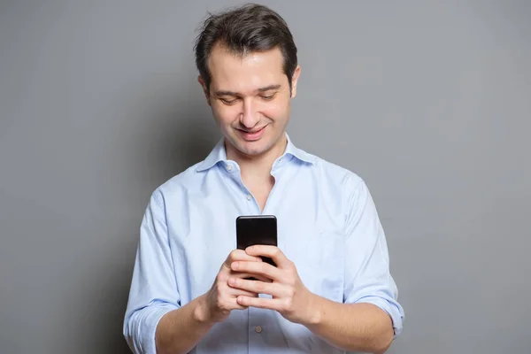 Studio portrait of young man texting on mobile phone