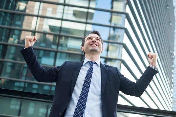 Businessman celebrating rising his arms after good news