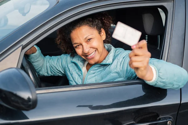 Black car driver woman smiling showing driving license