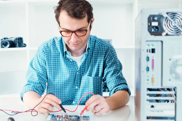 Expert man assembling pc and checking for problem