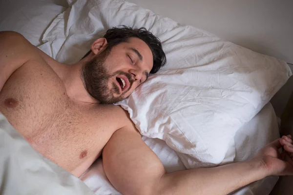 Портрет одного человека, спящего в постели и храпящего — стоковое фото