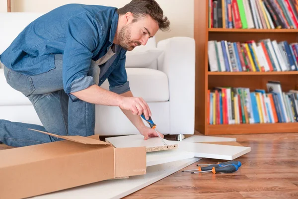 Nova casa e homem montando móveis fazê-lo sozinho — Fotografia de Stock