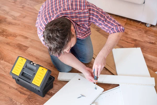 Mann porträtiert und selbst Möbel montiert — Stockfoto