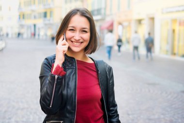 Mutlu genç öğrenci rahat telefon kullanarak ve CI içinde yürüyüş giymiş