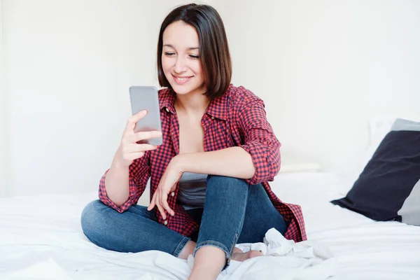 Young woman browsing internet on her mobile phone — Stock Photo, Image