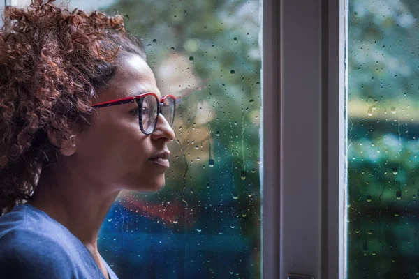 Eenzame zwarte vrouw in de buurt van venster denken over iets — Stockfoto