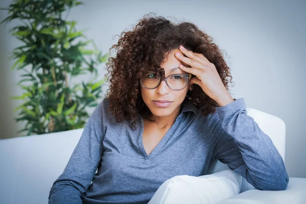 Orolig svart ung kvinna sitter i vardagsrummet hemma — Stockfoto