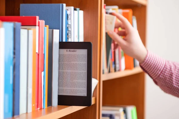 Mãos segurando e mantendo ebook na estante de fundo — Fotografia de Stock