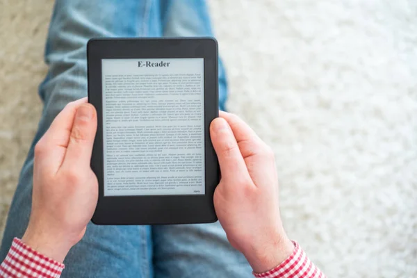 Ler um romance sobre o leitor de ebook em casa — Fotografia de Stock