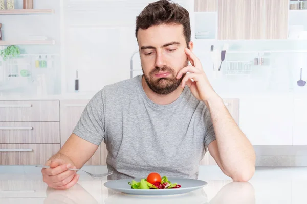 Worried man hungry and starved with salad — Stock Photo, Image