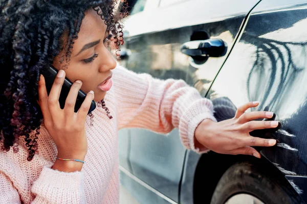 Mujer negra sintiéndose triste después de rascarse su auto — Foto de Stock