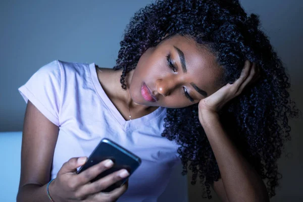 Portret van zwart meisje houden telefoon 's nachts — Stockfoto