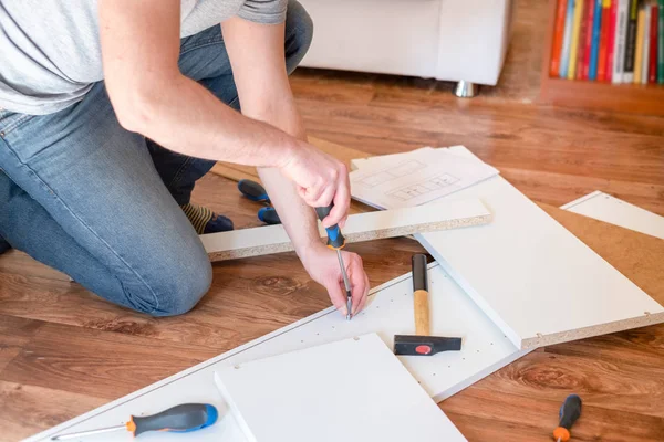 Mann liest die Anleitung zum Zusammenbau von Möbeln — Stockfoto