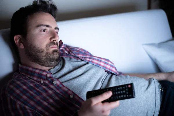 Líný člověk dívat se na televizi v noci sám — Stock fotografie