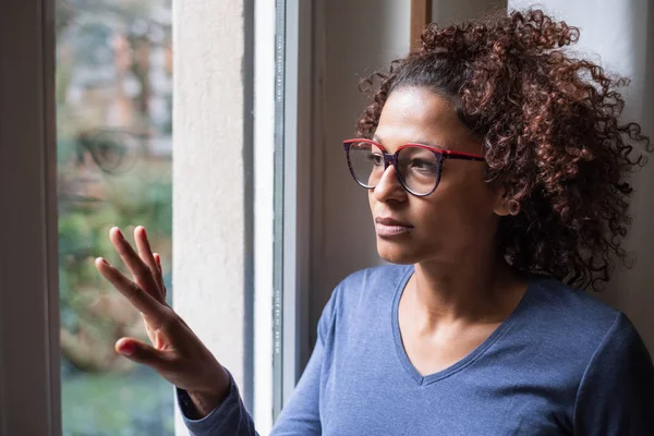 Traurige afrikanisch-amerikanische Mädchen, die aus dem Fenster schaut — Stockfoto