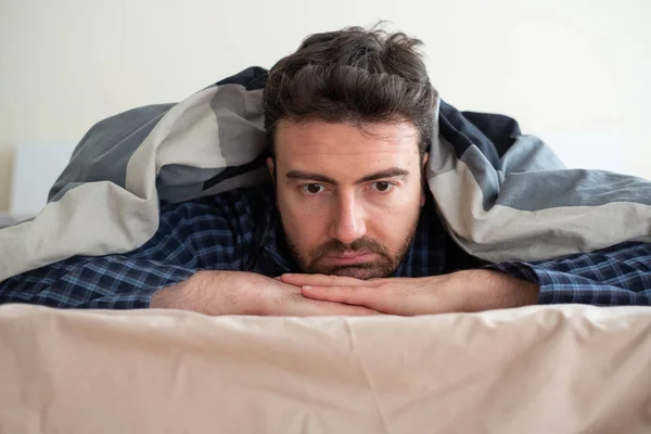 Člověk na portrétu trpící nespavostí snaže se usnout — Stock fotografie