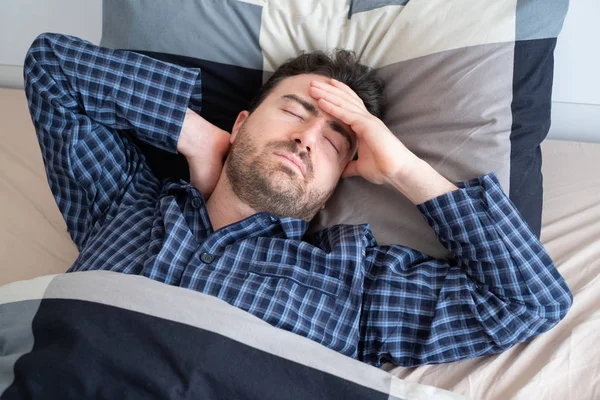 O homem está sentindo dor de cabeça e não consegue dormir — Fotografia de Stock