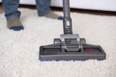 Beyaz halı elektrikli süpürge kullanarak vakumlama