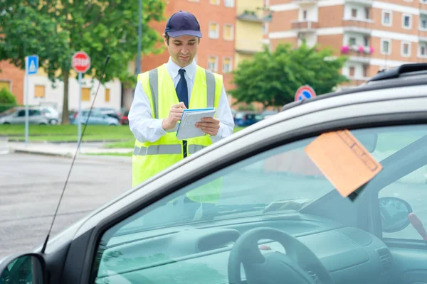 Egy parkoló warden írás egy parkolási büntetéséről szóló jegy — Stock Fotó