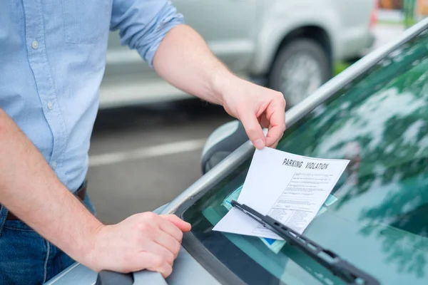 Aviso de violação de bilhete de estacionamento colocado sob limpador de pára-brisas — Fotografia de Stock