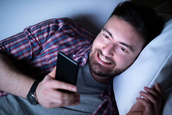 Счастливый человек по ночам разговаривает по мобильному телефону — стоковое фото