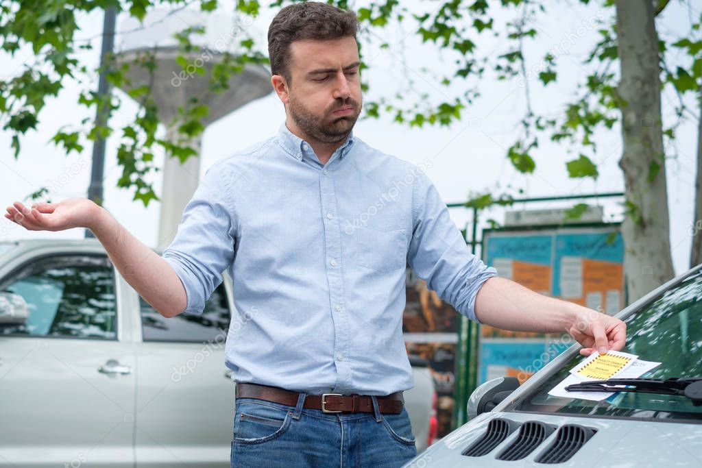 Surprised man finding parking ticket fine on his car