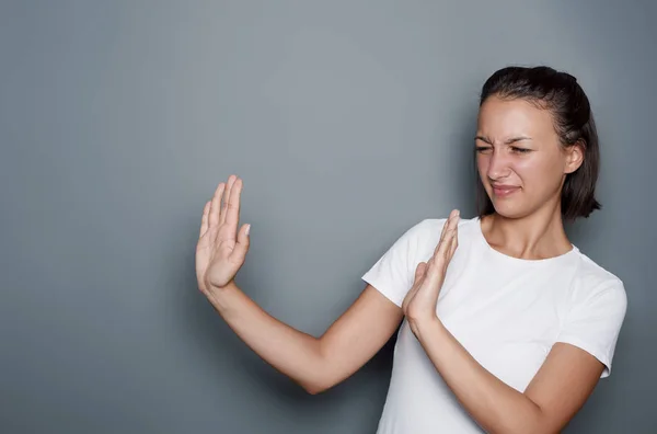 Woman rejecting hand gesture on gray background