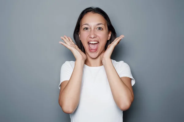 Geschokt gelukkig meisje portret op grijze achtergrond — Stockfoto