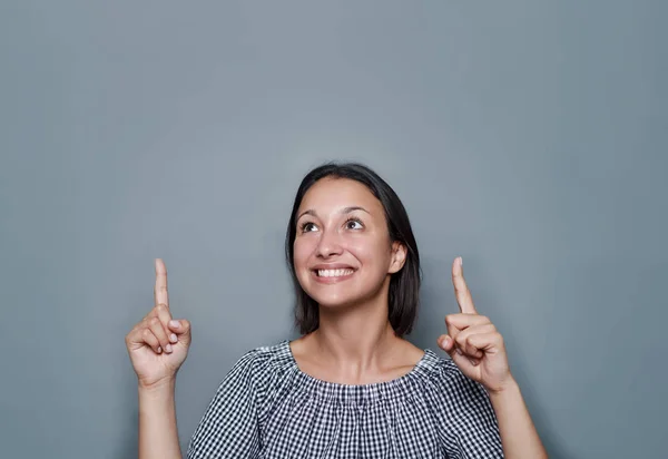 Vrouw die lege Kopieer ruimte op grijze achtergrond aanwijst — Stockfoto