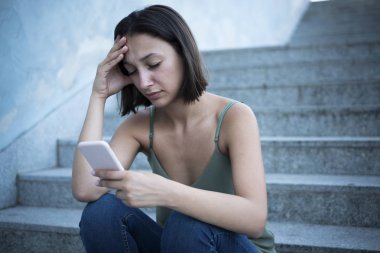 Üzgün kadın şehirde akıllı telefon online içerik kontrol